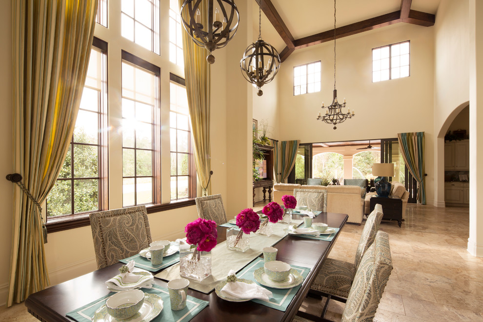 Large mediterranean dining room in Orlando with beige walls, limestone floors and beige floor.
