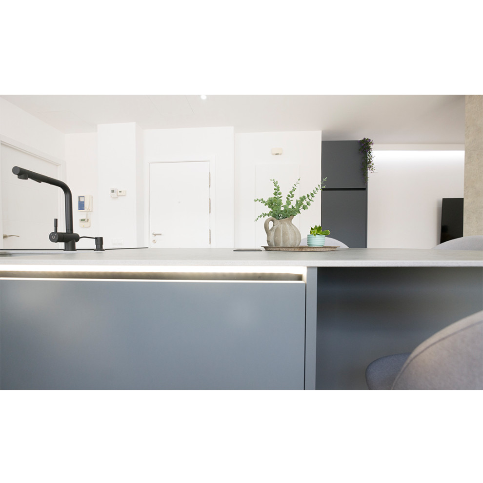 Bild på ett stort minimalistiskt grå grått kök och matrum, med en undermonterad diskho, grått stänkskydd, rostfria vitvaror, en köksö och brunt golv