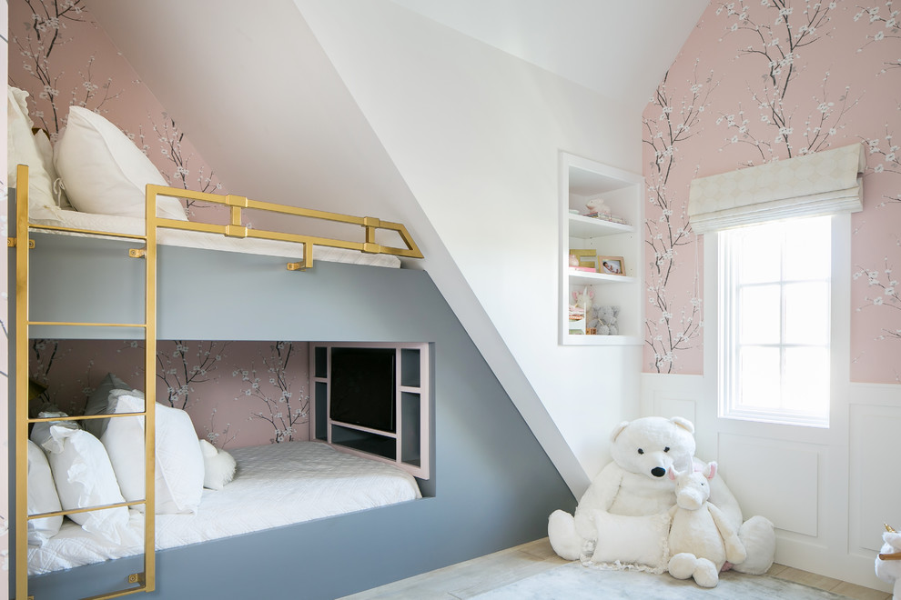 This is an example of a beach style kids' bedroom for kids 4-10 years old and girls in Orange County with pink walls and light hardwood floors.