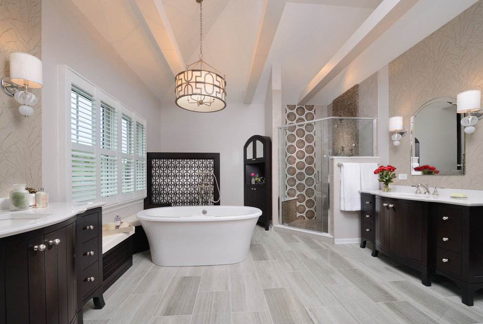 Example of a large transitional master brown tile and marble tile marble floor and gray floor freestanding bathtub design with brown cabinets, quartz countertops, a hinged shower door, beige walls, an undermount sink and flat-panel cabinets