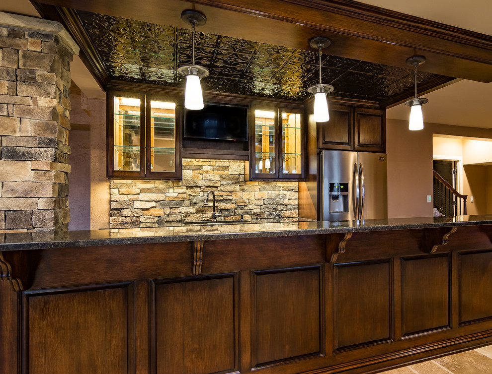 Large country galley wet bar in Kansas City with an undermount sink, glass-front cabinets, dark wood cabinets, granite benchtops, multi-coloured splashback, stone tile splashback and porcelain floors.