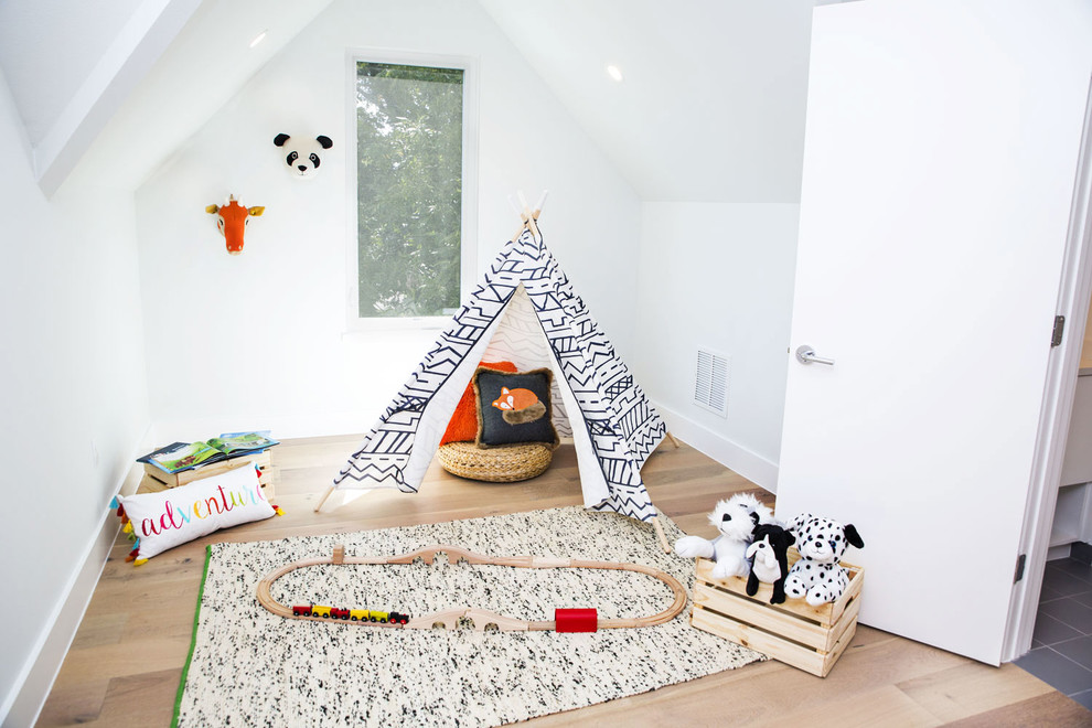 Scandinavian gender-neutral kids' playroom in Austin with white walls and light hardwood floors for kids 4-10 years old.