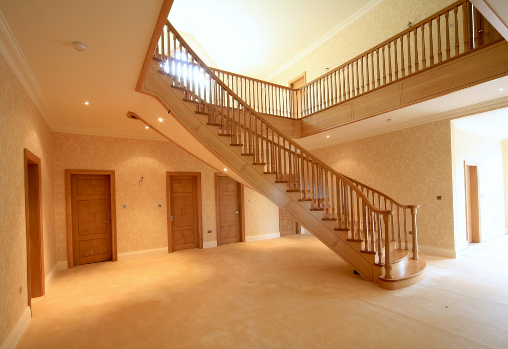 Photo of a large contemporary wood curved staircase in Other with wood risers.