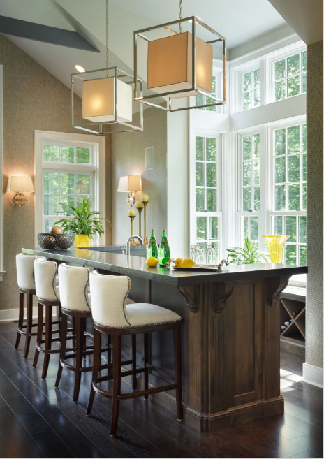 This is an example of a large transitional u-shaped seated home bar in Philadelphia with an undermount sink, recessed-panel cabinets, dark wood cabinets, granite benchtops, dark hardwood floors and brown floor.