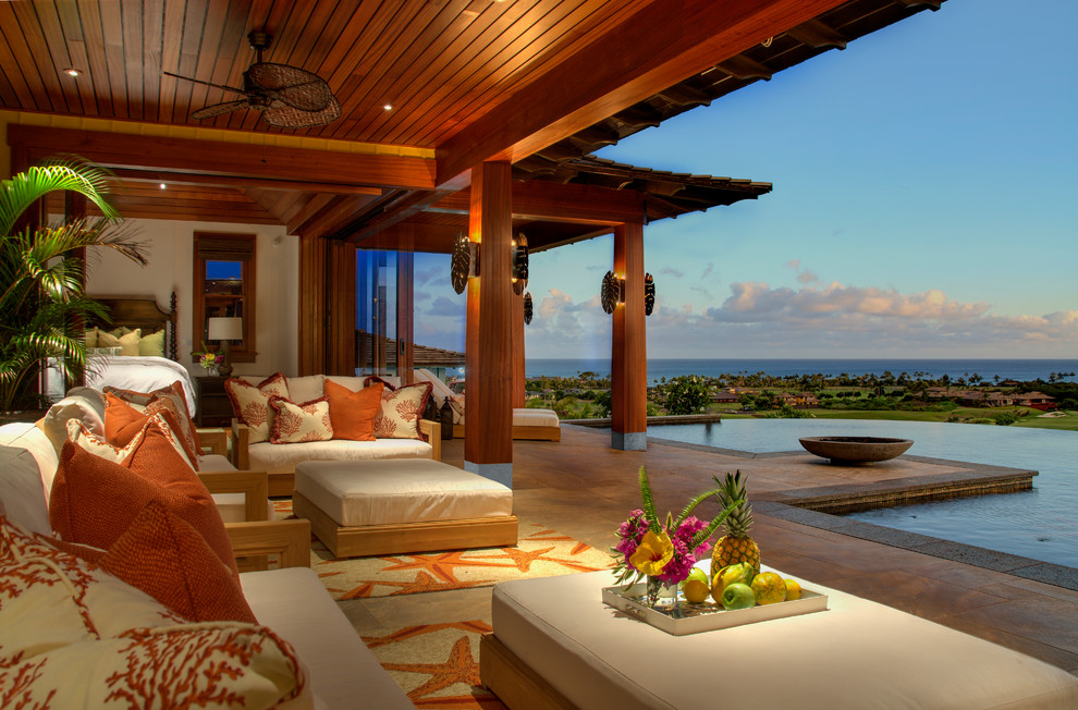 Inspiration for an expansive tropical backyard patio in Hawaii with a fire feature, tile and a roof extension.