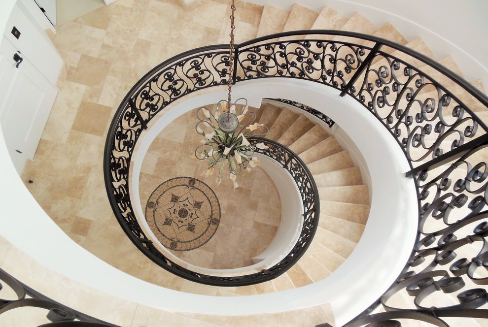 Diseño de escalera de caracol tradicional grande con escalones de piedra caliza, contrahuellas de piedra caliza y barandilla de metal