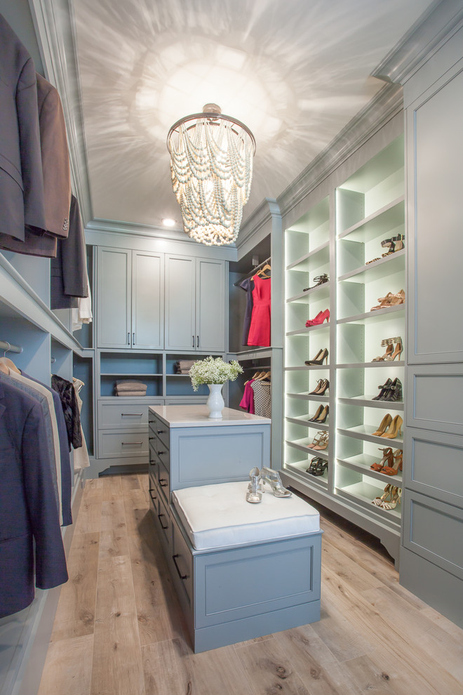 Inspiration for a mid-sized women's walk-in wardrobe in Grand Rapids with shaker cabinets and blue cabinets.