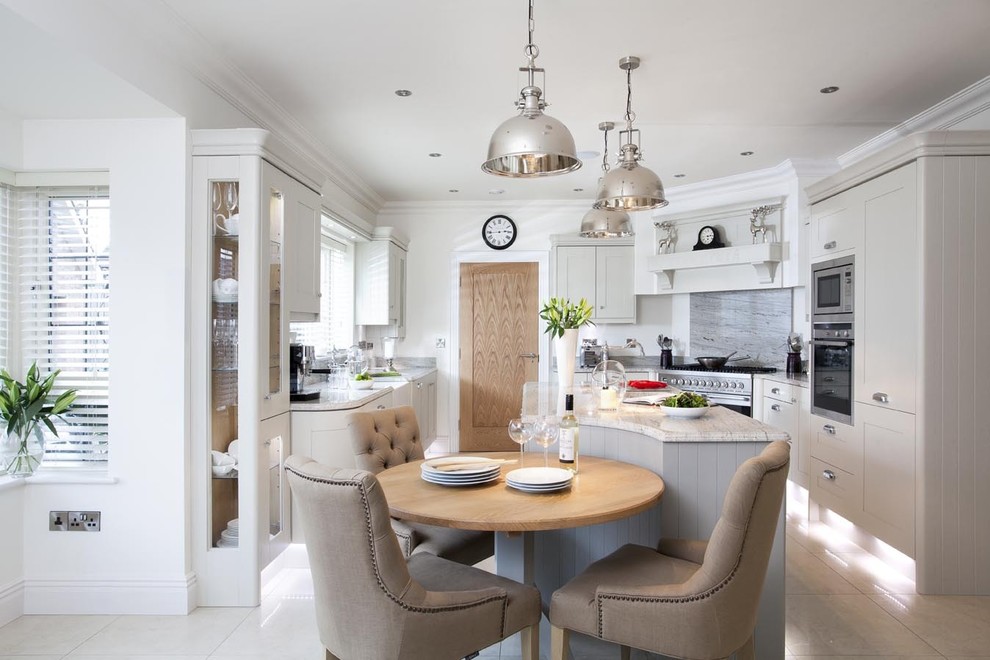 Inspiration for a transitional u-shaped eat-in kitchen in Belfast with a farmhouse sink, shaker cabinets, white cabinets, stainless steel appliances and grey splashback.