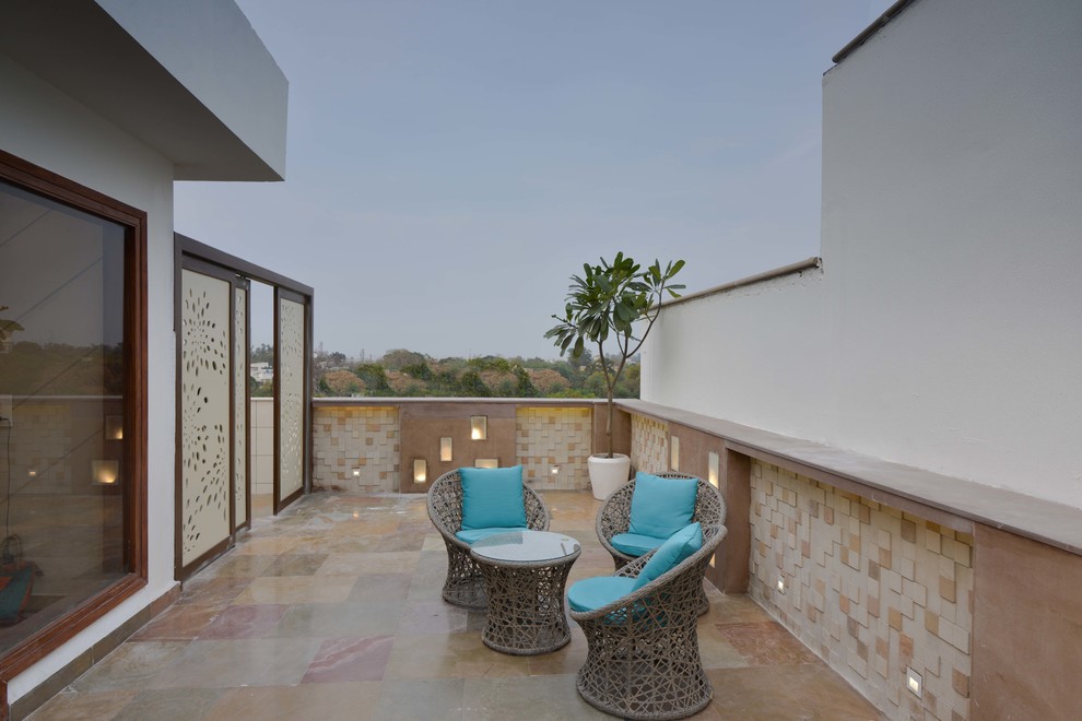 Inspiration for a mid-sized contemporary rooftop partial sun garden in Delhi with concrete pavers.