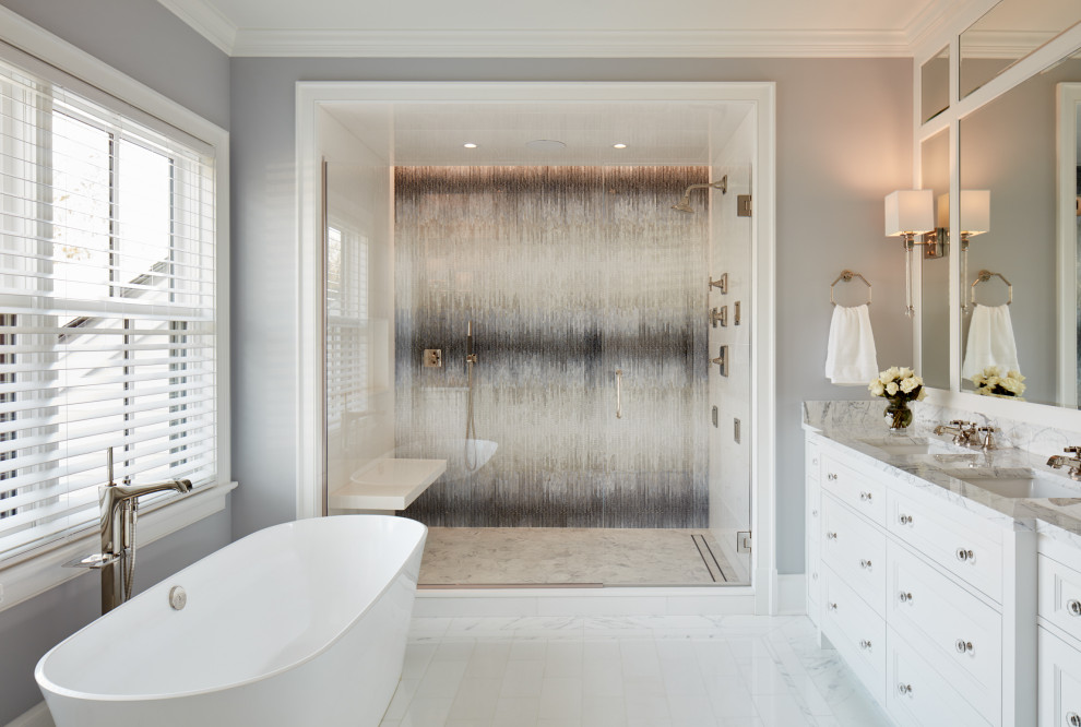 This is an example of a large country master bathroom in Chicago with white cabinets, a freestanding tub, a double shower, a one-piece toilet, white tile, marble, grey walls, marble floors, an undermount sink, marble benchtops, white floor and recessed-panel cabinets.