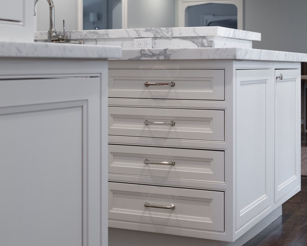 Expansive traditional l-shaped eat-in kitchen in Boston with an undermount sink, beaded inset cabinets, white cabinets, marble benchtops, grey splashback, marble splashback, stainless steel appliances, dark hardwood floors, with island, brown floor and white benchtop.