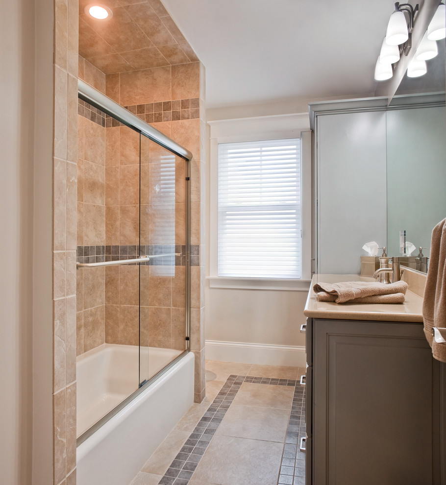 Example of a mid-sized transitional 3/4 multicolored tile and porcelain tile porcelain tile alcove bathtub design with an undermount sink, raised-panel cabinets, gray cabinets, solid surface countertops, a two-piece toilet and beige walls