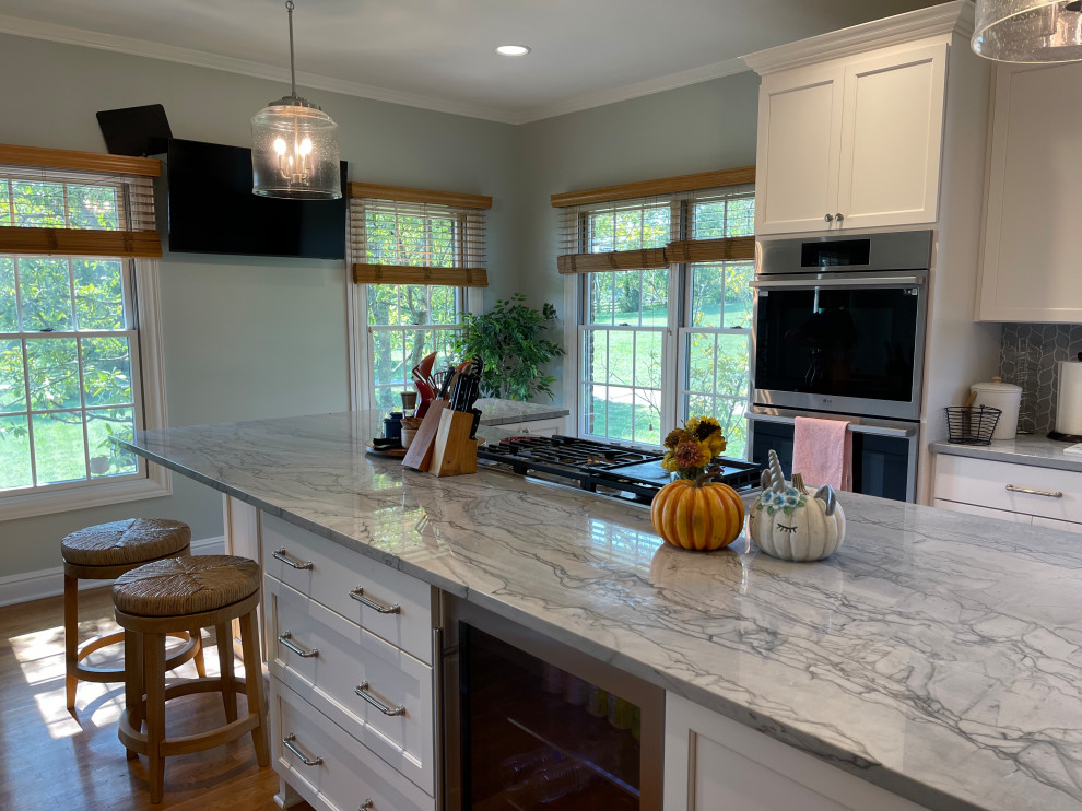 Eat-in kitchen - large transitional light wood floor and brown floor eat-in kitchen idea with an undermount sink, shaker cabinets, white cabinets, quartzite countertops, green backsplash, marble backsplash, stainless steel appliances, an island and gray countertops