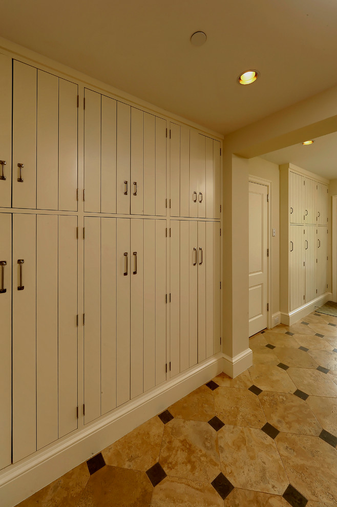 Photo of a mediterranean gender-neutral built-in wardrobe in DC Metro with flat-panel cabinets and porcelain floors.