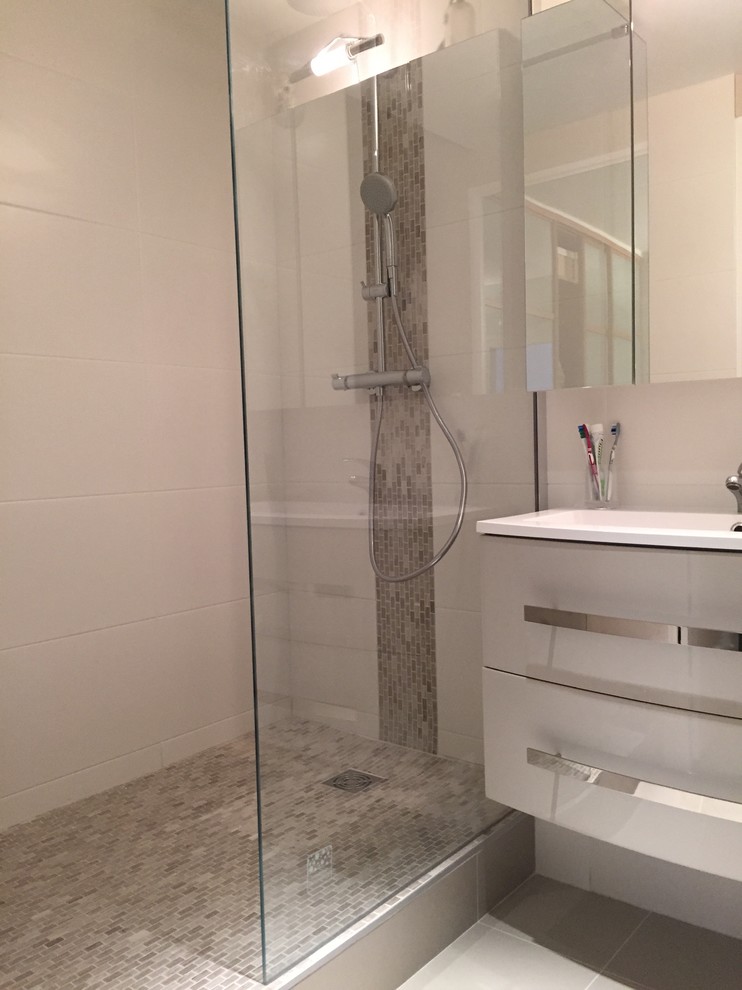 Small contemporary 3/4 bathroom in Paris with flat-panel cabinets, grey cabinets, a curbless shower, gray tile, ceramic tile, grey walls, ceramic floors, a console sink, glass benchtops, grey floor and a sliding shower screen.