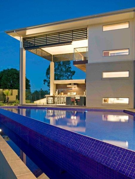 Inspiration for a large contemporary backyard custom-shaped infinity pool in Brisbane with a water feature and tile.