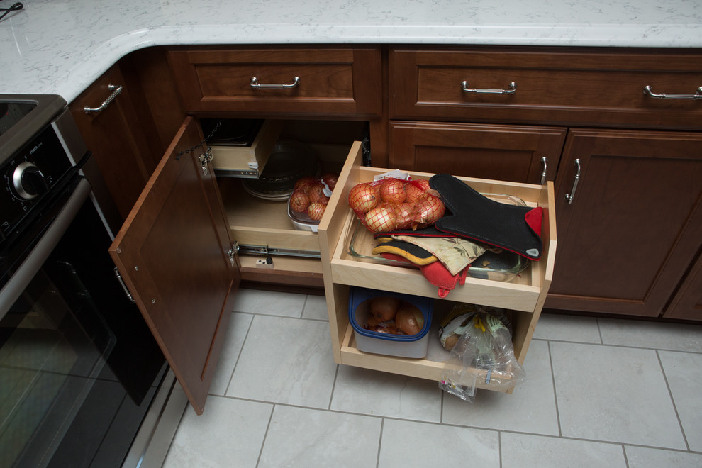 Mid-sized transitional l-shaped white floor and ceramic tile eat-in kitchen photo with quartz countertops, white countertops, an undermount sink, shaker cabinets, medium tone wood cabinets, white backsplash, porcelain backsplash, stainless steel appliances and a peninsula