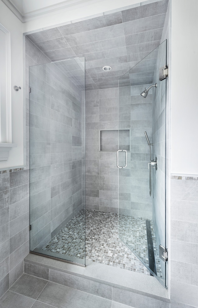 This is an example of a small modern 3/4 bathroom in New York with grey cabinets, an alcove shower, a two-piece toilet, gray tile, porcelain tile, white walls, porcelain floors, an undermount sink, grey floor and a hinged shower door.