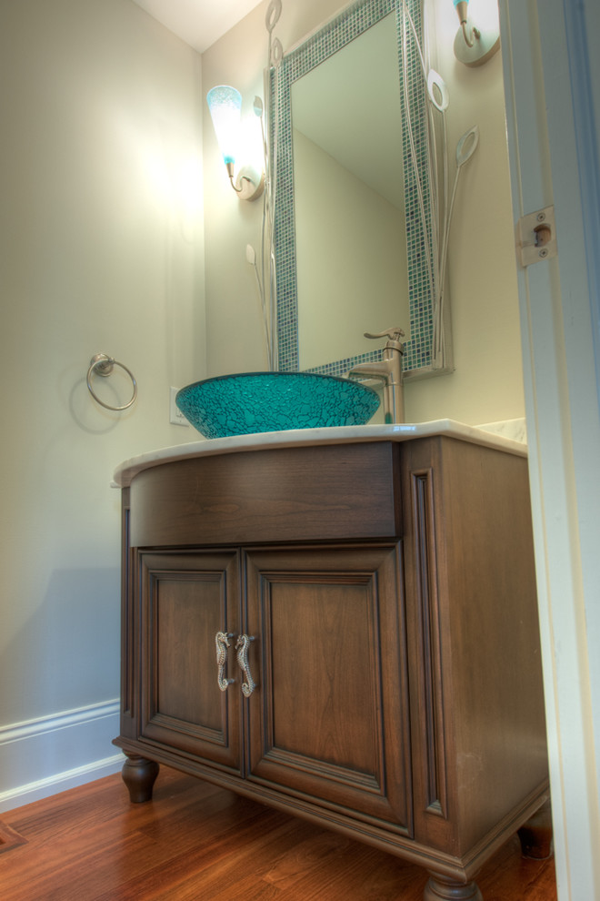 Photo of a small transitional powder room in Philadelphia with recessed-panel cabinets, medium wood cabinets, marble benchtops and medium hardwood floors.