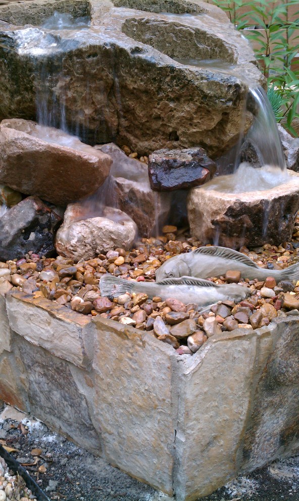 Modern garden in Austin with a water feature and natural stone pavers.