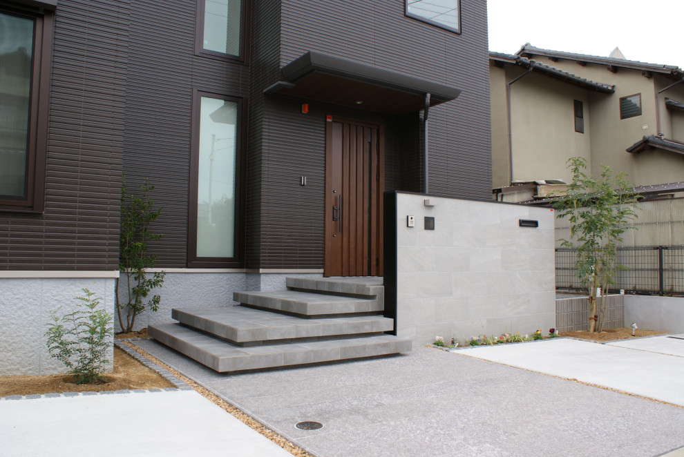 Esempio di un vialetto d'ingresso minimalista esposto a mezz'ombra di medie dimensioni e davanti casa in autunno con scale, pavimentazioni in pietra naturale e recinzione in metallo