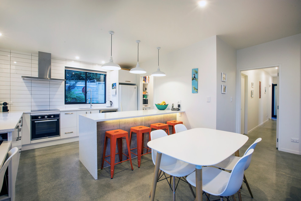 Small contemporary kitchen/dining combo in Auckland with white walls.