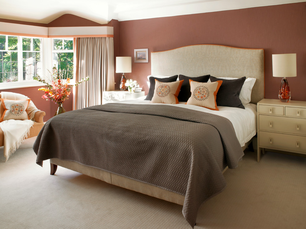 Mid-sized transitional master bedroom in London with carpet, brown walls and beige floor.