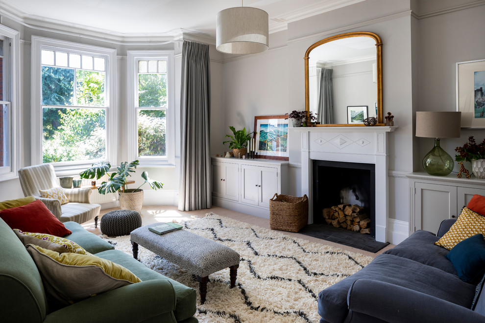 Photo of a mid-sized contemporary formal enclosed living room in London with grey walls, carpet, a standard fireplace, a metal fireplace surround and beige floor.