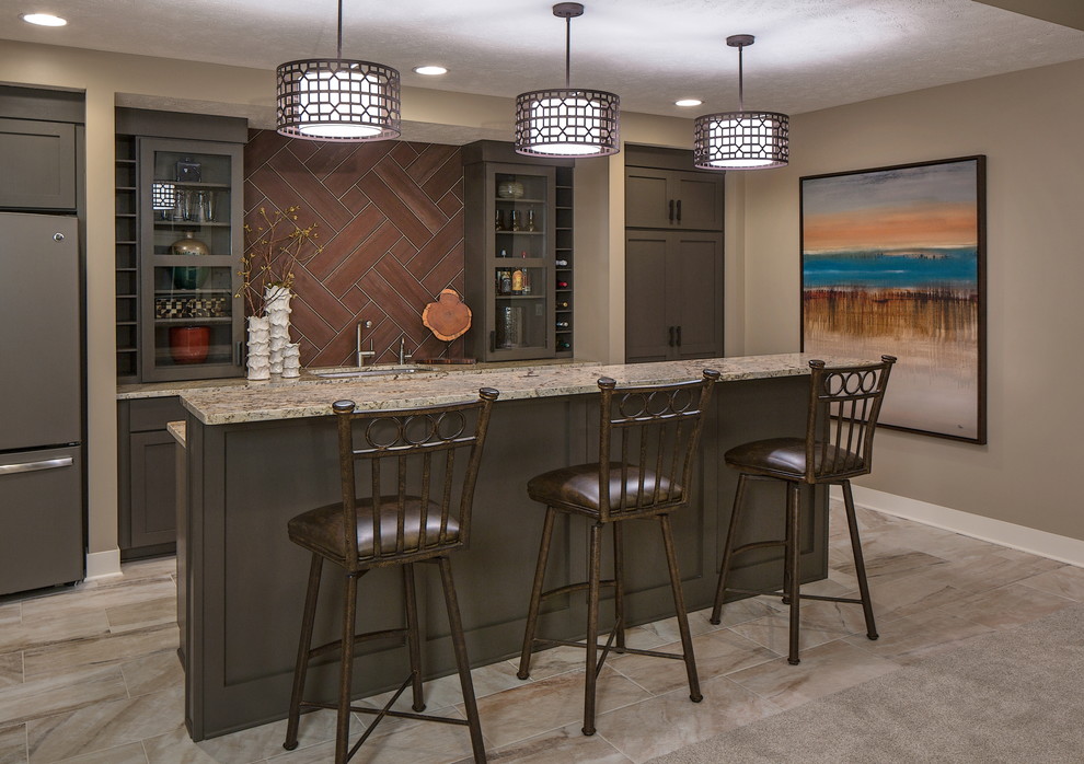 Inspiration for a transitional galley seated home bar in Omaha with an undermount sink, glass-front cabinets, grey cabinets and brown splashback.
