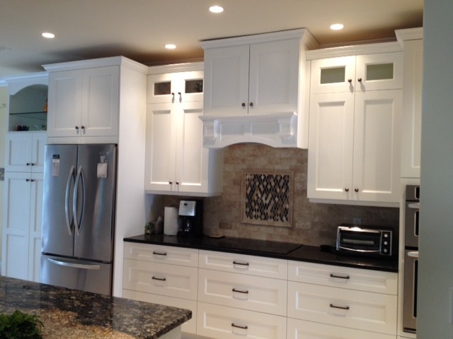 Inspiration for a mid-sized transitional travertine floor open concept kitchen remodel with an undermount sink, shaker cabinets, white cabinets, granite countertops, beige backsplash, stone tile backsplash, stainless steel appliances and an island