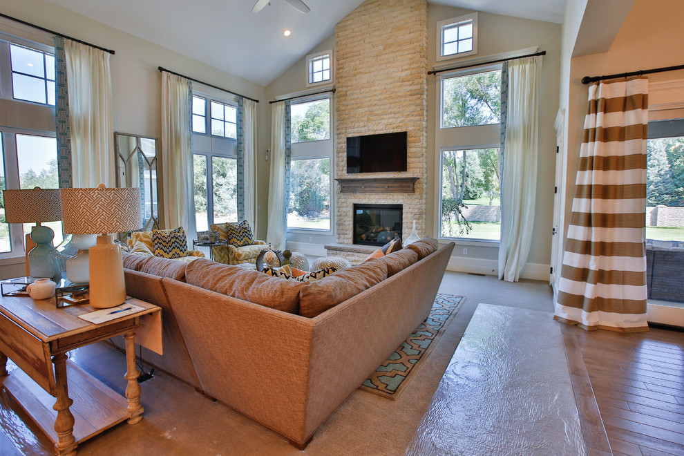 Large transitional open concept family room in Salt Lake City with grey walls, carpet, a standard fireplace, a stone fireplace surround and a wall-mounted tv.
