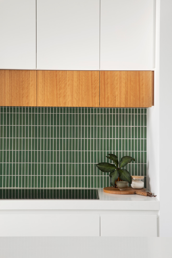 Inspiration för mellanstora moderna vitt kök, med vita skåp, grönt stänkskydd, stänkskydd i keramik, rostfria vitvaror, betonggolv, en köksö och grått golv