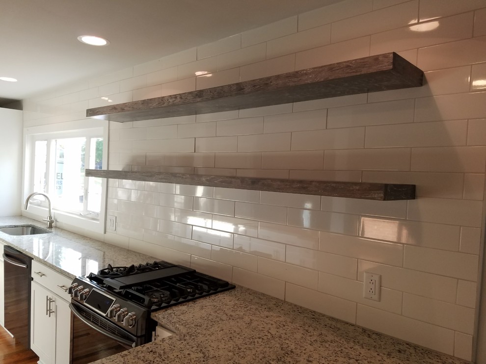 Inspiration for a mid-sized transitional l-shaped medium tone wood floor and brown floor open concept kitchen remodel with an undermount sink, recessed-panel cabinets, white cabinets, granite countertops, white backsplash, subway tile backsplash, black appliances, an island and beige countertops
