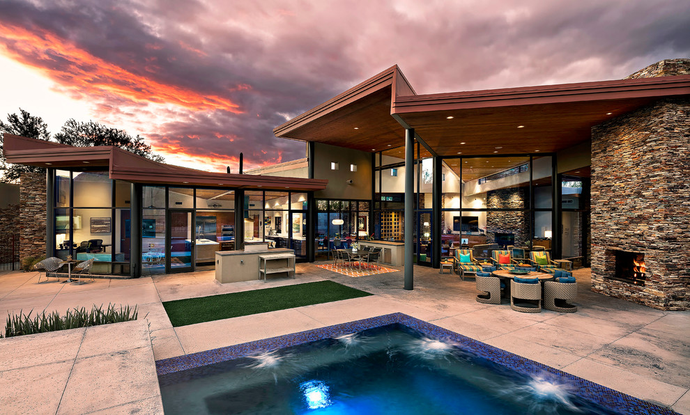 Inspiration for a contemporary backyard patio in Phoenix with an outdoor kitchen and a roof extension.