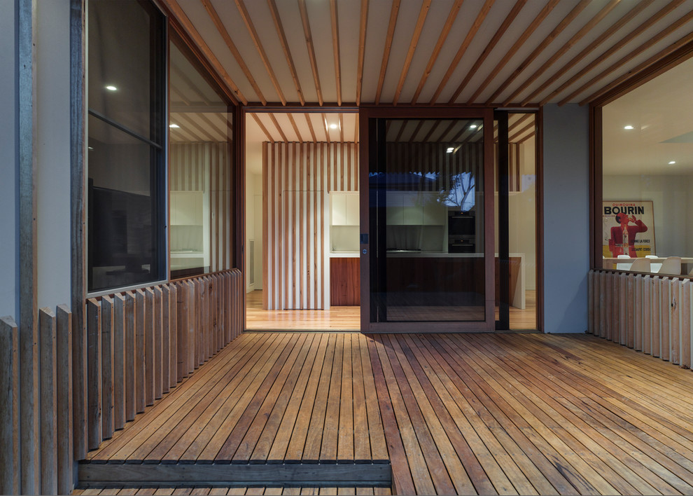 Design ideas for a large contemporary deck in Melbourne with a sliding front door and a medium wood front door.