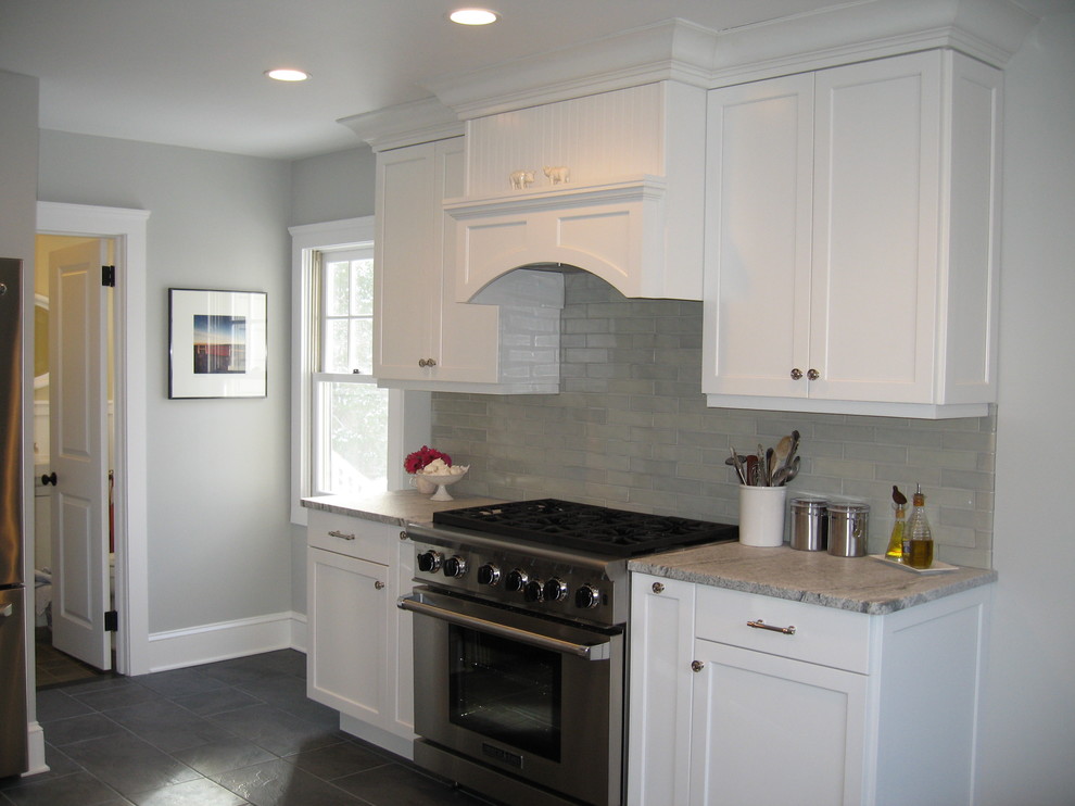 Eat-in kitchen - transitional slate floor eat-in kitchen idea in New York with a farmhouse sink, recessed-panel cabinets, white cabinets, paneled appliances, marble countertops, green backsplash and subway tile backsplash