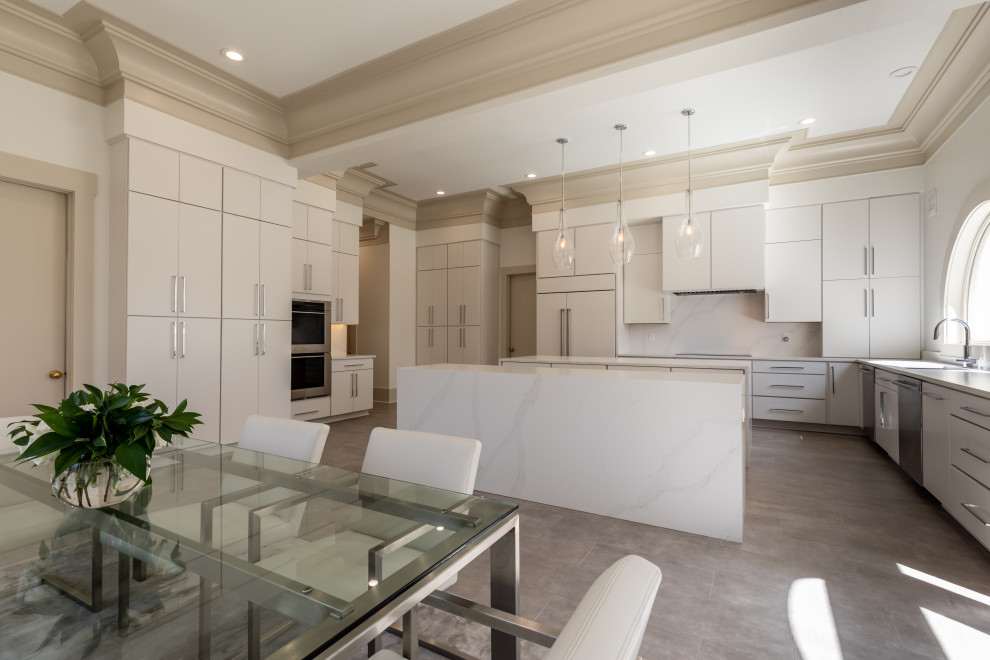 Large modern eat-in kitchen in DC Metro with white cabinets, quartzite benchtops, white splashback, stainless steel appliances, multiple islands, grey floor and white benchtop.