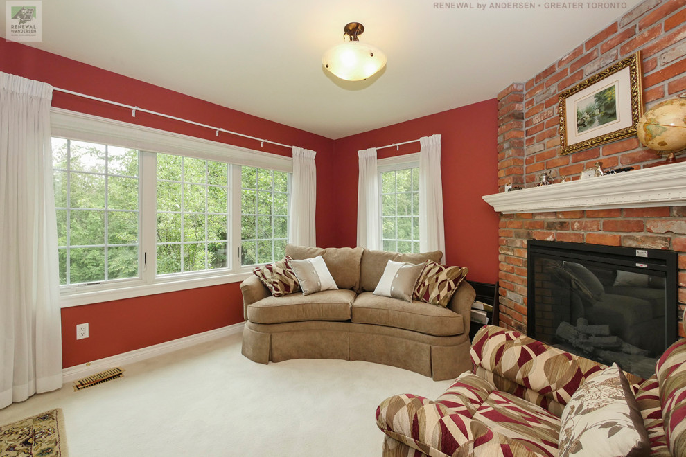Foto di un soggiorno di medie dimensioni e chiuso con pareti rosse, moquette, camino ad angolo, cornice del camino in mattoni, nessuna TV e pavimento beige