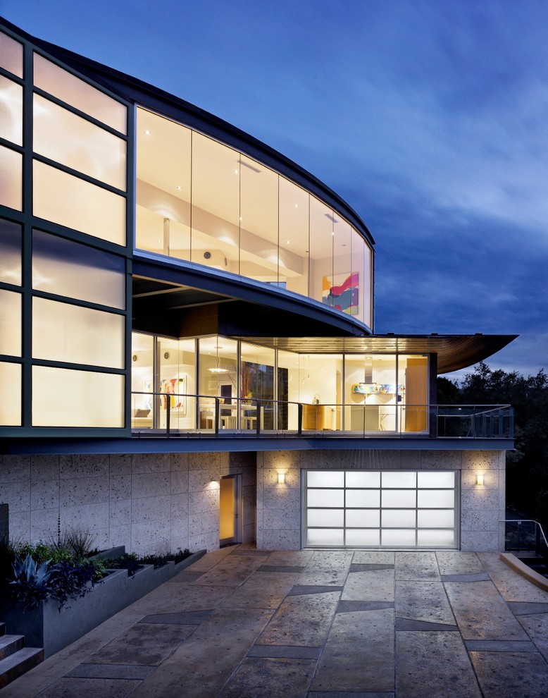 Photo of a large modern two-storey glass grey house exterior in Other with a flat roof.