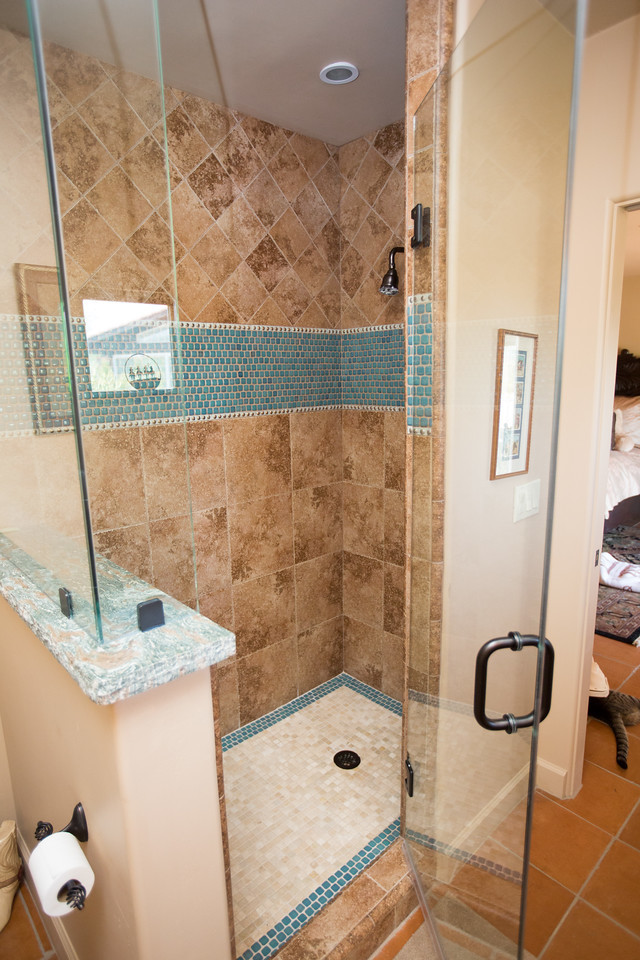 Photo of a mid-sized 3/4 bathroom in Phoenix with raised-panel cabinets, medium wood cabinets, an alcove shower, a one-piece toilet, beige tile, limestone, beige walls, terra-cotta floors, a drop-in sink, granite benchtops, orange floor and a hinged shower door.