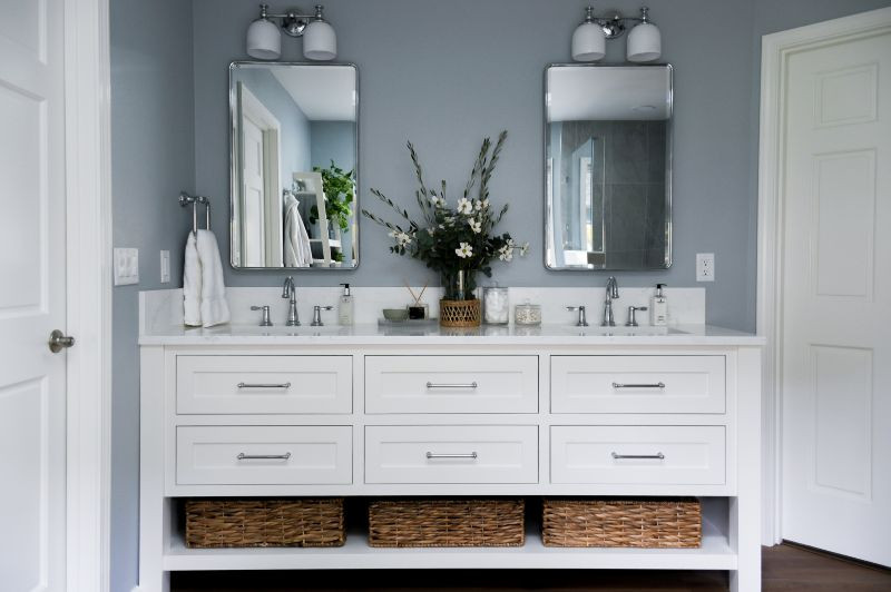 Inspiration for a transitional master multicolored tile vinyl floor, brown floor and double-sink corner shower remodel with shaker cabinets, white cabinets, blue walls, an undermount sink, quartz countertops, a hinged shower door, white countertops and a built-in vanity