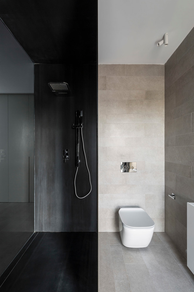 Photo of a modern bathroom in Valencia with a wall-mount toilet, beige tile, black tile, beige floor and an open shower.