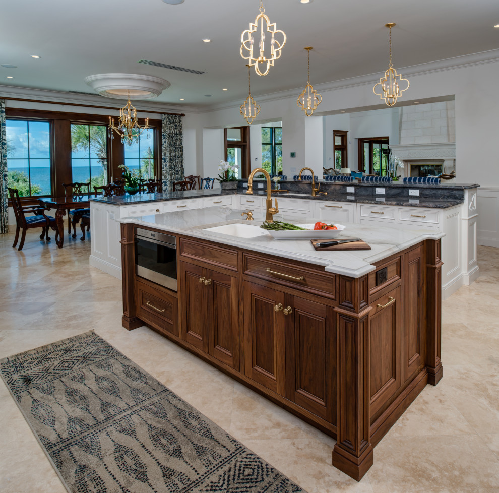 Expansive transitional l-shaped eat-in kitchen in Other with an undermount sink, raised-panel cabinets, white cabinets, quartzite benchtops, blue splashback, glass tile splashback, stainless steel appliances, terrazzo floors, with island and multi-coloured benchtop.