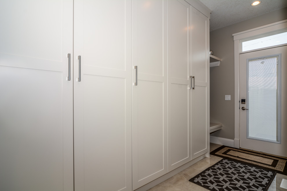 Mid-sized transitional porcelain tile mudroom photo in Calgary with gray walls and a glass front door