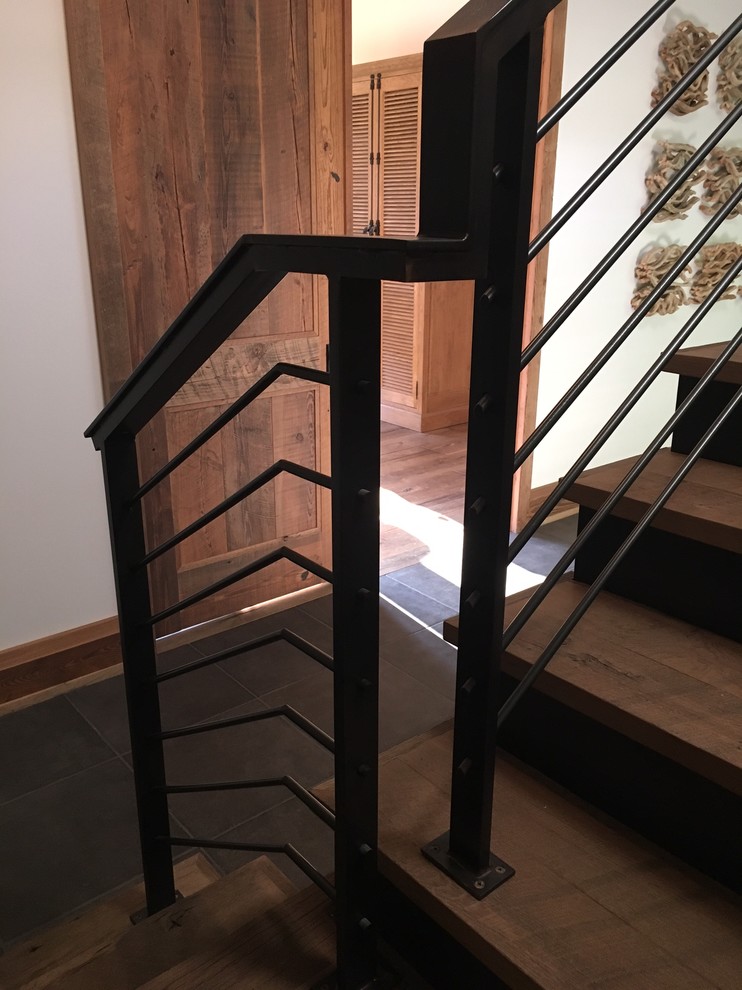 Photo of a large country wood l-shaped staircase in Indianapolis with metal risers and metal railing.