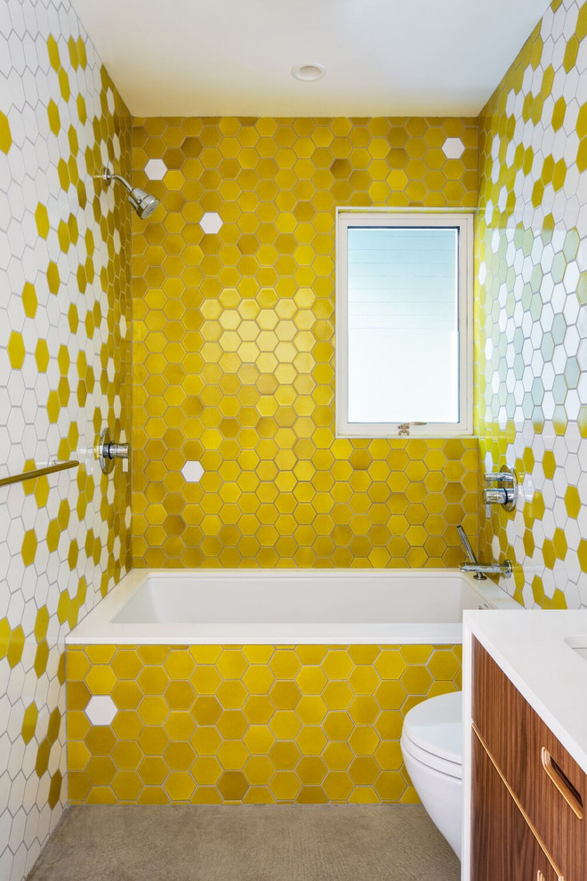 Inspiration for a midcentury kids bathroom in San Francisco with a shower/bathtub combo, multi-coloured tile, multi-coloured walls, concrete floors, ceramic tile and a single vanity.
