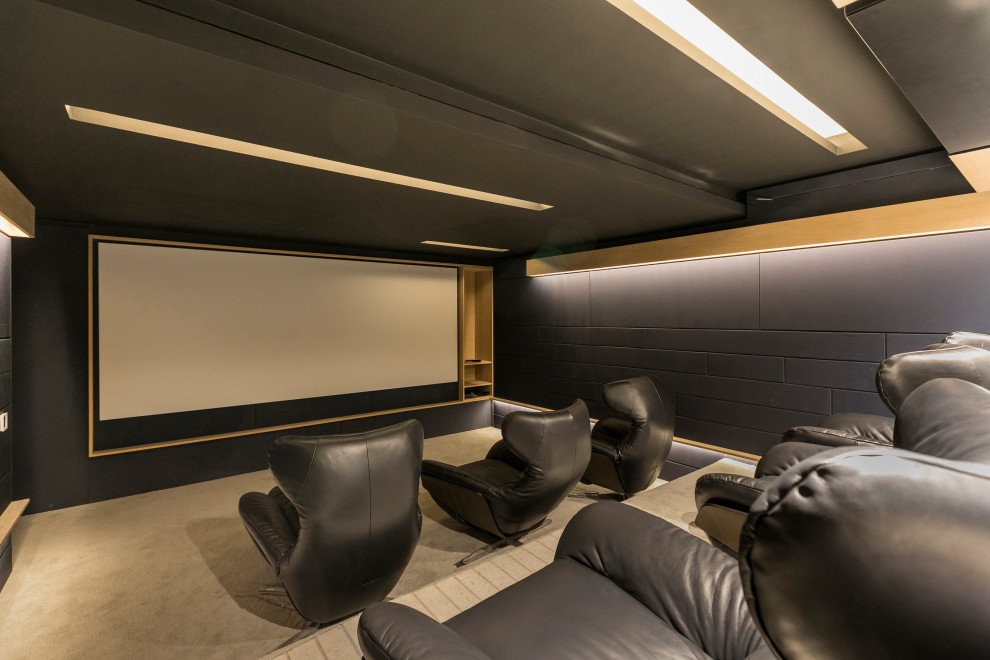 Photo of a contemporary enclosed home theatre in Other with grey walls, carpet, a projector screen and grey floor.