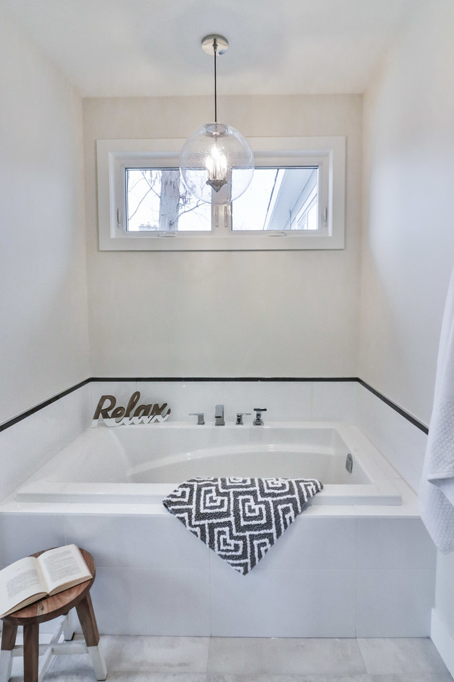 Example of a mid-sized transitional master white tile and porcelain tile porcelain tile and gray floor drop-in bathtub design with flat-panel cabinets, gray cabinets, a one-piece toilet, gray walls, an undermount sink and quartz countertops