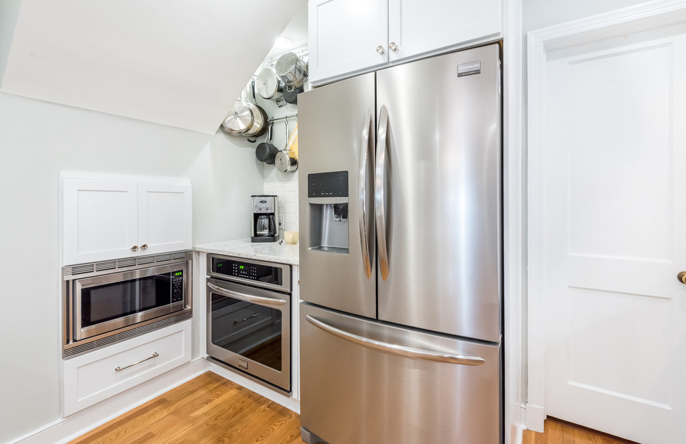 Example of a transitional medium tone wood floor kitchen design in Richmond with a single-bowl sink, shaker cabinets, white cabinets, quartzite countertops, white backsplash, mosaic tile backsplash, stainless steel appliances and a peninsula