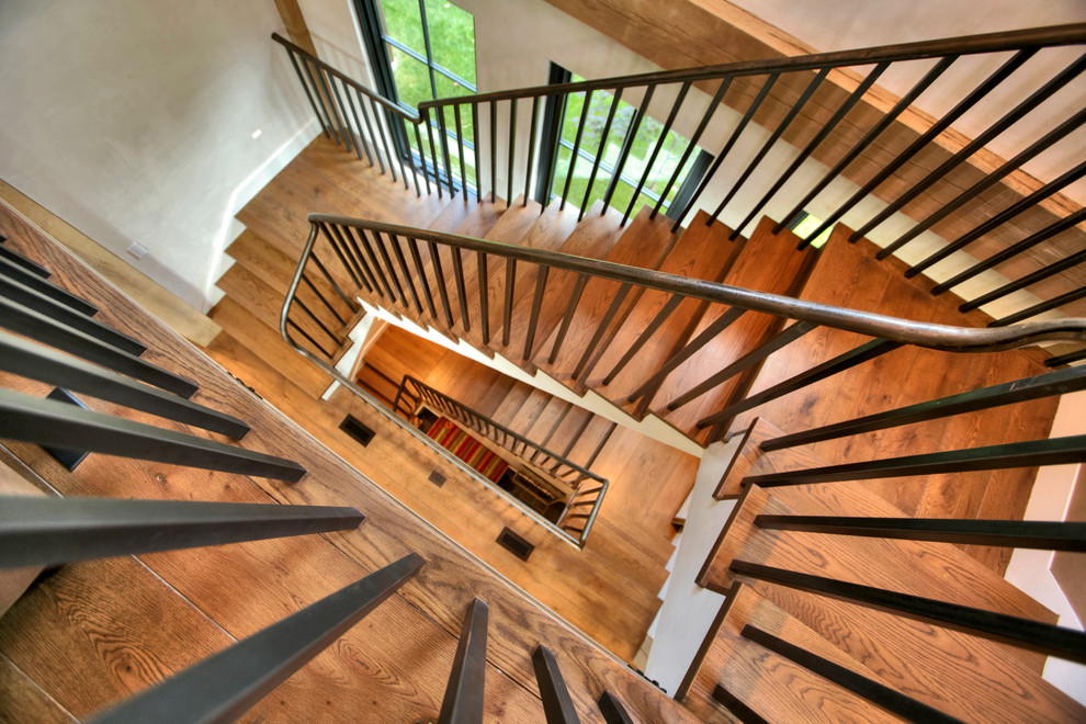 Photo of a large industrial wood floating staircase in New York with wood risers and metal railing.